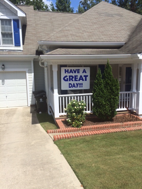 Home with sign in front yard reading "Have a great day"